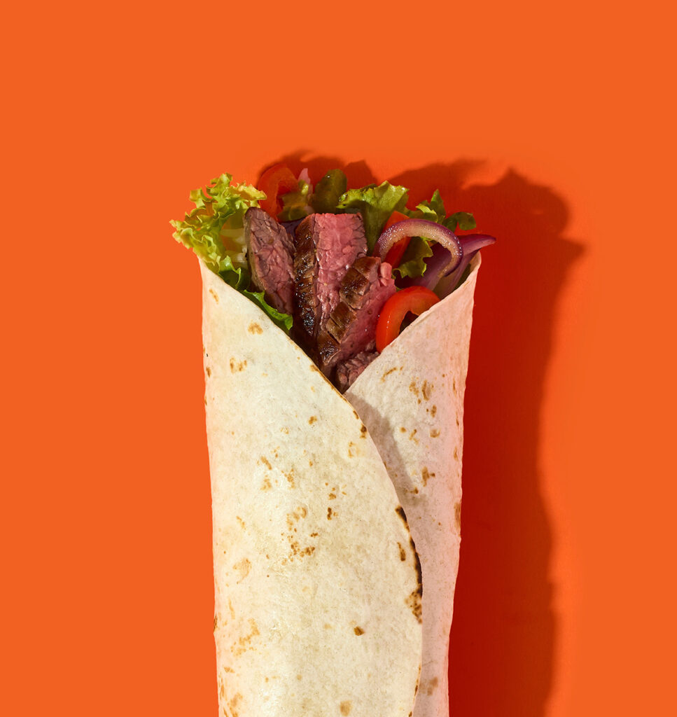 Steak burrito on an orange background